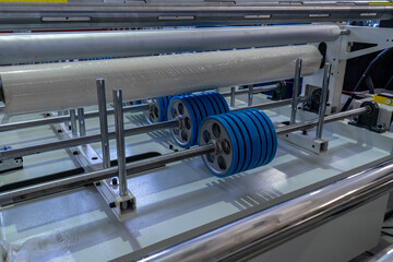 Blue Rubber Rollers and White Film Roll on Industrial Machine