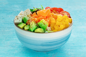 Salmon poke bowl with mango, avocado, tofu, wakame, cherry tomatoes