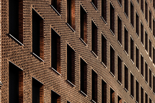 Geometric brick texture architecture facade detail in Hamburg Germany with abstract pattern relief shadows and strong diagonal zigzag surface