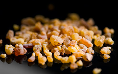 Frankincense olibanum resin, Boswellia sacra Isolated on black background. Frankincense or olibanum fragrant aromatic resin used in incense and perfumes, border design, macro shot