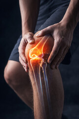 Person Holding Knee with Glowing Digital Joint Pain Illustration on Dark Background