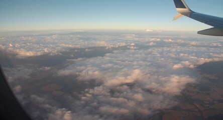 Fototapeta premium Elevated airplane perspective showcasing vast cloud fields over landscape