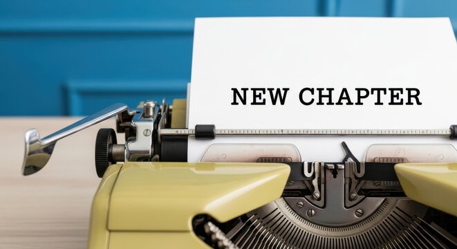 Vintage yellow typewriter with white paper and text NEW CHAPTER on a wooden desk with a blue wall background, symbolic of a new beginning, life change, and fresh starts.