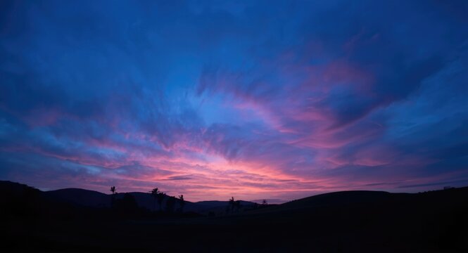 Colorful twilight sky with vibrant blue and orange clouds over abstract nature scene