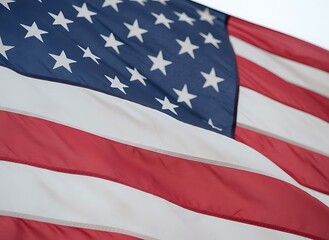 American flag waving in the wind with red white and blue colors and white stars on a clear sky background