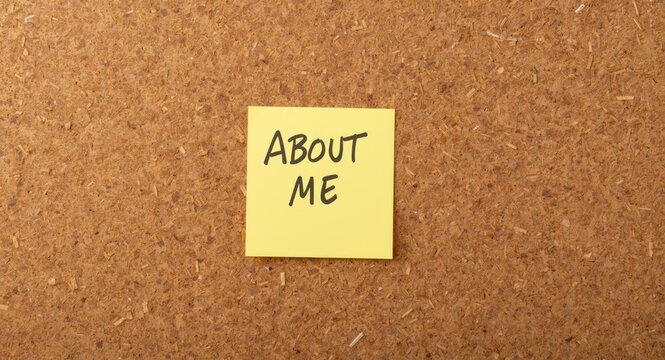 Corkboard background with bright sticky note reading about me for self introduction use