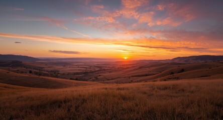 Obraz premium Expansive outdoor landscape showing hills and a valley with sunset colors
