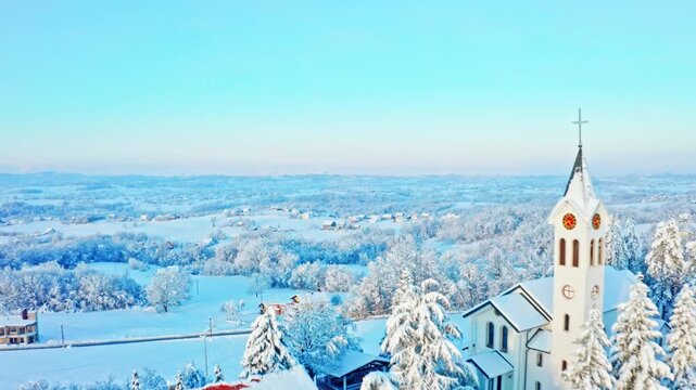 Aerial Winter Village with Snow-Covered Church and Countryside Landscape