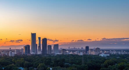 Fototapeta premium Colorful sunset bathes urban horizon alongside far mountains illustrating the arrival of a new season