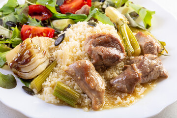 Braised turkey with fennel served on couscous with vegetables and marsala sauce, hearty main dish.