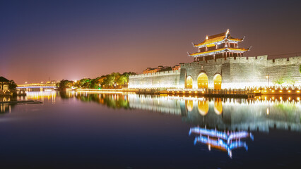 Fototapeta premium Night View of Ancient Chinese City Gate by River