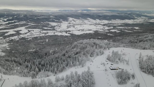 Mountains with snow-covered pine trees in winter. Panoramic aerial drone view. Ski or snowboard  resort in winter. Ukraine, Carpathians, Play. Aerial panoramic drone view from above, top view from dro