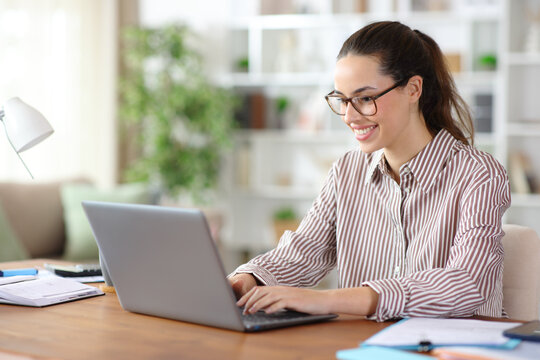 Happy tele worker wearing eyeglasses working online at home