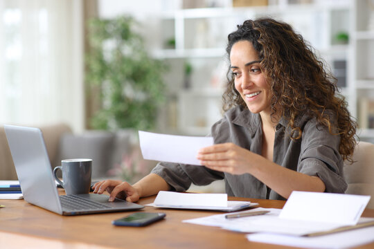 Happy freelancer checking bills and doing online accounting