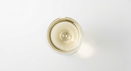 Aerial perspective of a wine glass filled with light white wine showcased on a white background