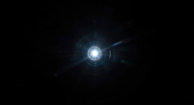 Detailed close up of a locked projector lens glowing with intense white light flare in darkness