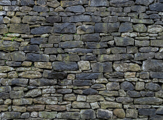 Obraz premium Close-up of aged dry stone wall limestone blocks with rough texture.