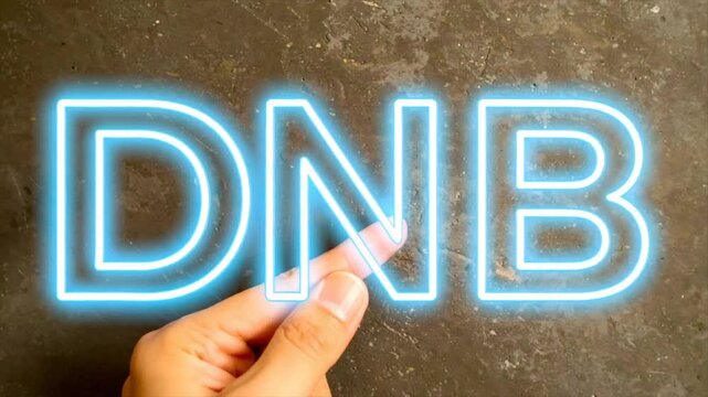 A hand touches a neon-lit "DNB" sign against a mottled gray surface