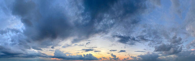 Obraz premium Sunset landscape. Blue sky, sun light and dark blue clouds