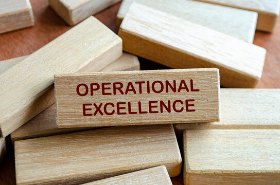 OPERATIONAL EXCELLENCE text on wooden blocks with ladder on notebook symbolizing structured improvement and high performance culture.