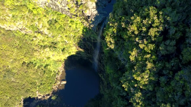 Aerial orbit shot of Lagoa do Vento waterfall in Rabacal, drone revealing a hidden lagoon and water flowing through rocks towards Cascata do Risco edge in Madeira mountains, travel adventure.