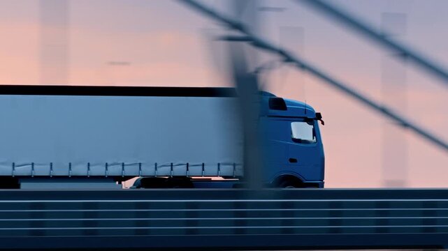 Electric semi truck driving across suspension bridge at sunset