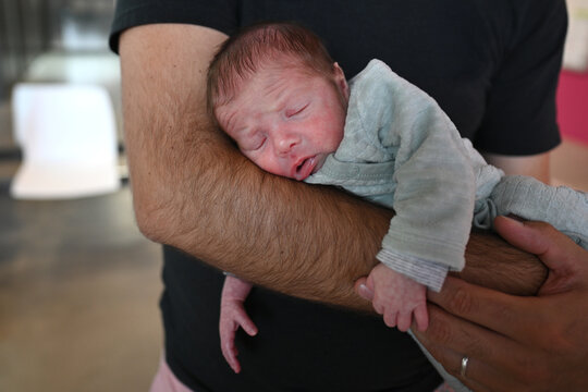 Infant in his father's arms in a moment of tenderness