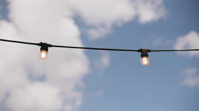 Two light bulbs are hanging on a wire illuminating the courtyard in the house. Close-up shooting