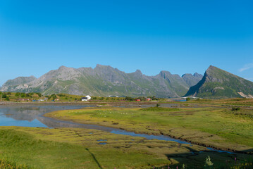 Landscape near Fredvang with the Fredvang Bridges and the distinctive peak of Volandstind. Lofoten in Norway.