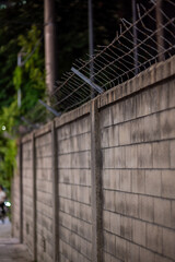 Fototapeta premium Concrete wall with barbed wire security fence