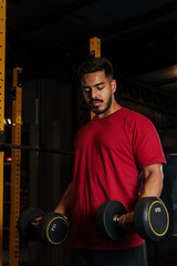 Focused Athlete Training Arms with Dumbbells During Strength Workout