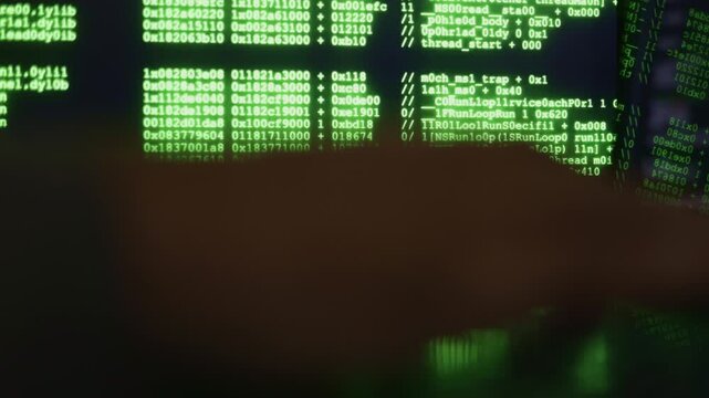 Mysterious digital operation in dim light, concealed programming on monitor under subdued lighting conditions, encrypted script execution reflected on desk amidst low glow of covert hacking