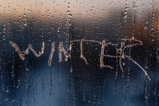 The word WINTER is scratched on the frozen winter glass