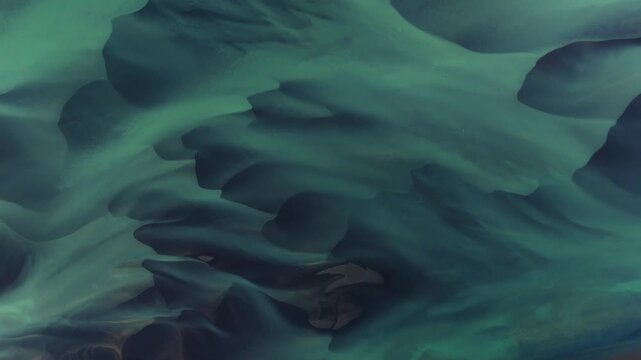 Aerial view of glacial river patterns creating an intricate tapestry of textures and tones, showcasing nature's artistry, Selfoss, Iceland.