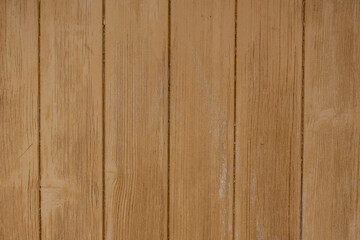 Fototapeta premium A close-up photograph of weathered wooden planks with fine sand visible in the gaps between the boards, the natural grain, knots, and warm tones of the wood in bright, directional sunlight