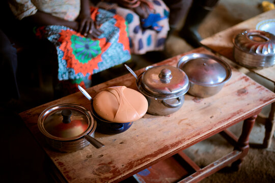 Colorful skirts and metal pots on a rustic wooden table in a cozy setting. Kigali, Rwanda