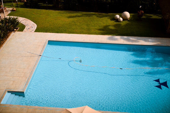 A clean, empty swimming pool with blue water surrounded by a well-maintained garden lawn. Kigali, Rwanda