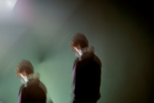 Blurred silhouette of a person in motion with a green background. Germany