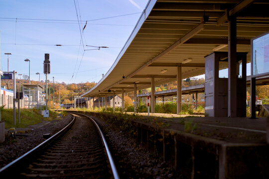 Empty railway station platform on a sunny autumn day with clear blue sky. Germany
