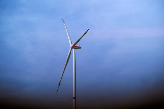 Lone wind turbine against a clear blue sky at dusk. Germany