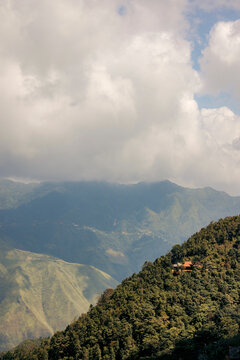 Mountain landscape with lush green forest under a sky filled with dramatic clouds. Mountains of Ta Xua, Bac Yen District, Son La, Vietnam