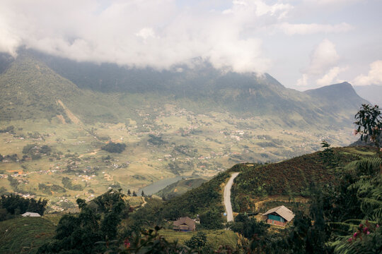 Rolling hills and clouds over a scenic village landscape with distant mountains. Sapa, Vietnam