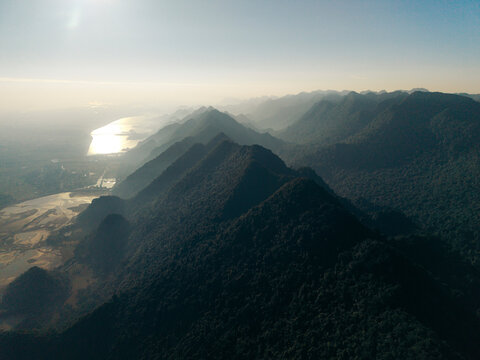 Aerial view of a mountain range with shadows under a clear blue sky at sunset. Yen Thuy District, Hoa Binh, Vietnam