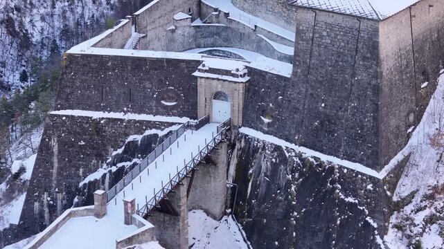 Aerial view of the snow-dusted Forte di Exilles, its stone walls contrasting with the stark white of the snow-covered landscape, Exilles, Piemonte, Italy.
