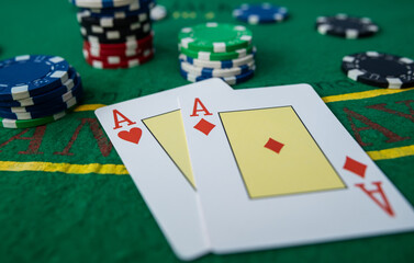 Pair of aces in poker game with casino chips on green felt background