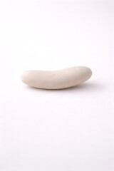 Single smooth, light-colored, elongated, natural river stone on white seamless background
