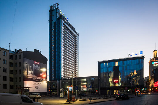 RIGA, LATVIA. 14th June 2022.  The Radisson Blu Hotel Latvija skyscraper and commercial buildings in the city center at dusk with advertisements and street lights.
