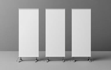 Three blank white display boards standing on metal stands in a gray room