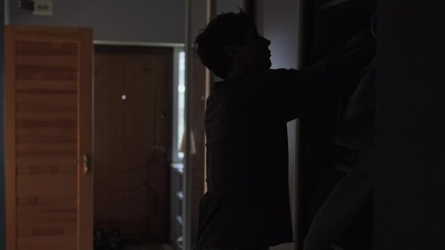 Emotional suppression and avoidance behavior, man hiding problems in closet at home as metaphor of repressed feelings, mental health struggle, inner chaos and psychological overload