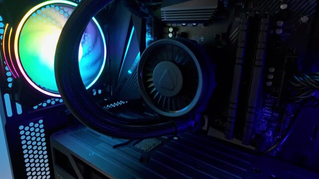 Slow motion downward movement revealing complete gaming computer system, rgb illumination, cooling hardware, powerful desktop setup designed for modern gaming performance